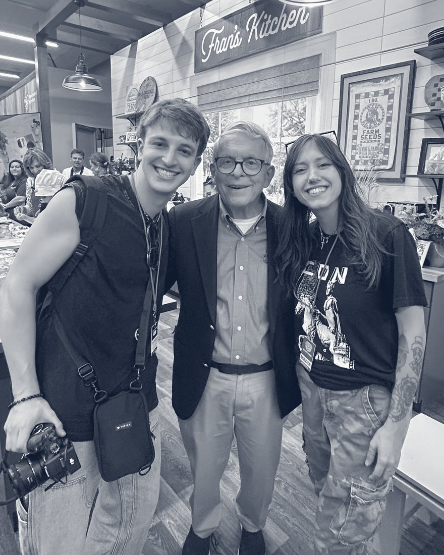 Anthony Schilt with a camera, Governor Mike DeWine, and Bridgette Kidd at the Ohio State Fair